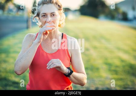 Echte junge reife kaukasische Frau in einer Sportkleidung im Park an einem sonnigen Nachmittag. Stockfoto