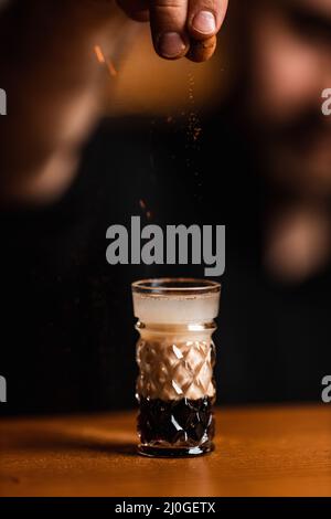 Der Barkeeper bereitet in der Bar einen Cocktail zu Stockfoto