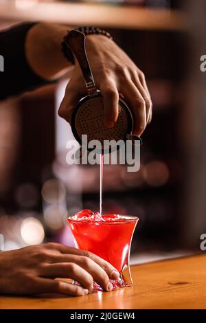 Der Barkeeper bereitet in der Bar einen Cocktail zu Stockfoto