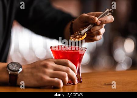 Der Barkeeper bereitet in der Bar einen Cocktail zu Stockfoto