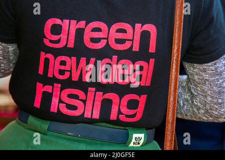 Green New Deal Entstehen, Logo auf Hemd in Blackpool, Lancashire.UK 19. März 2022; Boris Johnson wird zur Frühjahrstagung der Konservativen Partei nach Blackpool Winter Gardens zurückkehren. Die Ankunft der Delegierten für zwei Tage mit Reden und Debatten wird die wichtigste Veranstaltung in dem neuen Komplex seit der Renovierung sein. Anforderungen. Anti-Tory-Demonstranten und Aktivisten versammeln sich an der Strandpromenade mit Fahnen, Gewerkschaftsbannern, Plakaten, Publikationen und handgeschriebenen Schildern, um gegen die Tory-Regierung zu protestieren. Credit MediaWorldImages/AlamyLiveNews Stockfoto