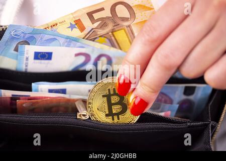 Bitcoin Münzen in der Handtasche der Frau Stockfoto