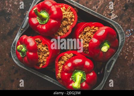 Süße rote Paprika gefüllt mit Fleisch und Tomaten in einem Vintage-Bratblech. Draufsicht Stockfoto