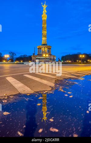 Die berühmte Siegessäule im Tiergarten in Berlin, Deutschland, in der Abenddämmerung, mit einer Spiegelung in einer Pudd Stockfoto