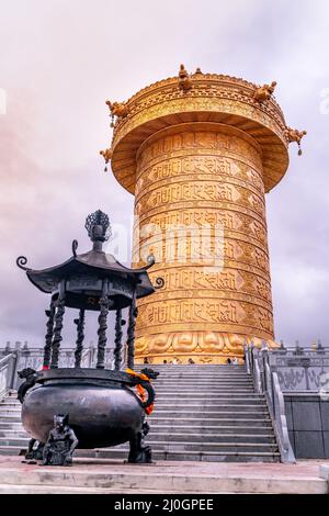 Die große goldene, rollende Gebetstrommel im tibetisch-buddhistischen Kloster Stockfoto