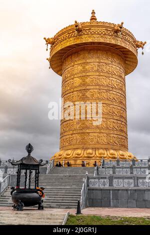 Die große goldene, rollende Gebetstrommel im tibetisch-buddhistischen Kloster Stockfoto