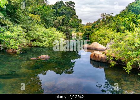 Der atemberaubende Blick auf den Wasserfluss des Wasserfalls im Yanoda Rain Forest Nationalpark auf Hainan in China Stockfoto