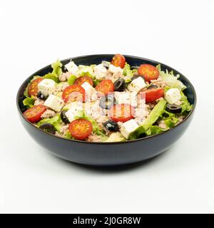 Salat, Avocado, Thunfisch, Tomaten, Feta in einer Schüssel auf weißem Hintergrund - Studioaufnahme Stockfoto