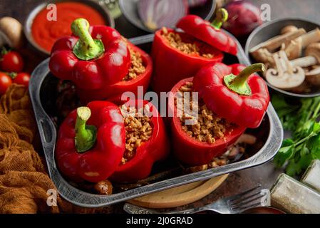 Süße rote Paprika gefüllt mit Fleisch und Tomaten in einem Vintage-Bratblech. Draufsicht Stockfoto