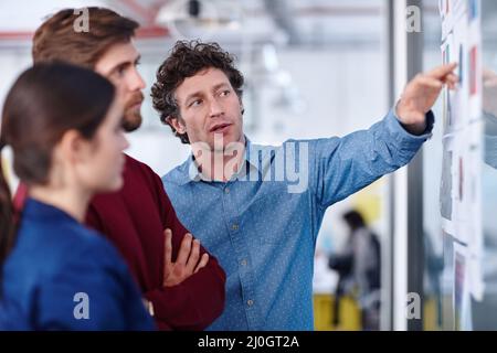 Eingetaucht in ihr neuestes Projekt. Aufnahme einer Gruppe von kreativen Profis, die gemeinsam an Designs arbeiten. Stockfoto