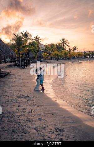 Paar am Strand von Curacao während des Sonnenuntergangs, Männer und Frauen beobachten den Sonnenuntergang am tropischen Strand von Curacao Stockfoto