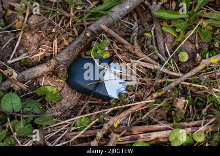Elektronikschrott in Form einer Computermaus wird auf der Strecke weggeworfen und vergiftet die Natur Stockfoto