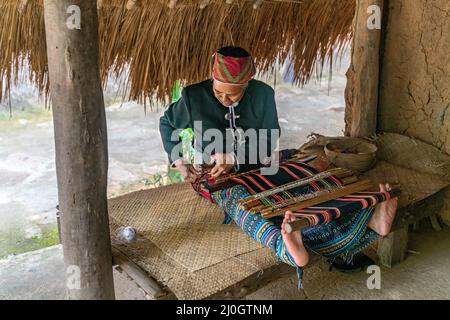 Alte Frau näht in traditionellem Stammeskleid Stockfoto