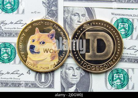 Calgary, Alberta, Kanada. 22.Mai 2021. Ein paar Dogecoin mit einem Dollar Scheinen auf dem Hintergrund. Stockfoto