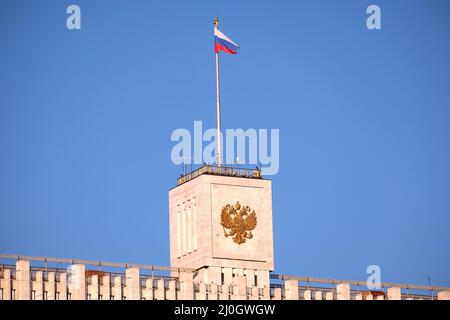 Russische Flagge auf dem Gebäude der Regierung der Russischen Föderation gegen klaren blauen Himmel Stockfoto