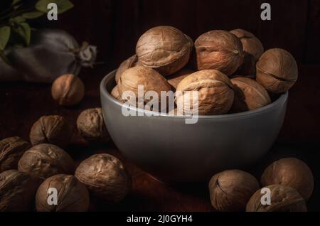 Walnüsse auf dunklem Hintergrund im rustikalen Stil Stockfoto