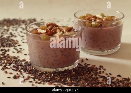 Schwarzer Reispudding. Hergestellt mit schwarzem Reis, in Milch geschmoren, mit Zucker gesüßt und mit Kardamom gewürzt. Reis wird beim Kochen lila. Es ist das Stockfoto