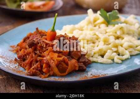 Szeged Gulasch auf dunklem Holz Stockfoto