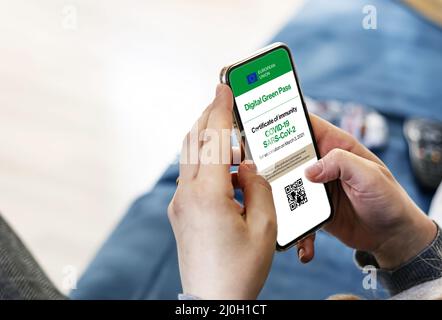 Frau mit einem Smartphone mit digitalem Covid-19-Zertifikat auf dem Bildschirm Stockfoto