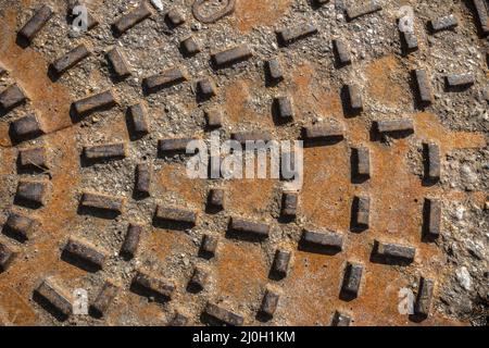 Rostiger Kanaldeckel Stockfoto