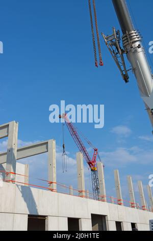 Ein Blick auf eine Baustelle mit Baukräne und blauem Himmel. Stockfoto