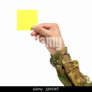 Ausgeschnittene Aufnahme einer nicht erkennbaren Männerhand, die einen gelben Notizbuch auf einem weißen isolierten Hintergrund hält Stockfoto