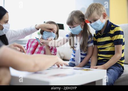 Frau auf Kinder Gesundheit zu überprüfen, bitten, Gesichtsmaske tragen, verhindern covid Ausbreitung Stockfoto