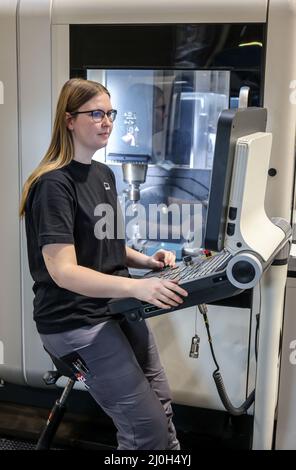 Oberhausen, Nordrhein-Westfalen, Deutschland - Auszubildende Frau im Metallhandwerk. Auszubildender Maschinenführer bei einer CNC-Werkzeugmaschine im MAN-Ausbildungszentrum. MA Stockfoto