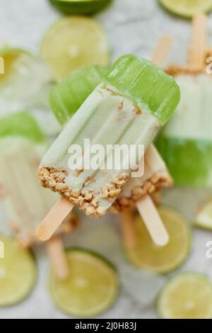 Nahaufnahme der Hand des Kindes mit farbenfrohem Limonen- und Cremetepfelsaft Stockfoto