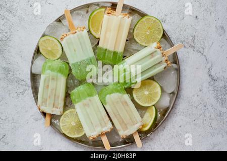 Sommer erfrischend hausgemachte Limettenpopsicles mit abgebrochtem Eis auf Stein Hintergrund Stockfoto