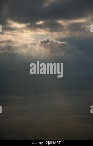 Vertikale Aufnahme des göttlichen Sonnenlichtes durch die Wolken an einem Abend Stockfoto