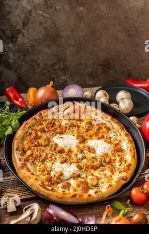 Leckere Pizza, um viele Gemüse auf schwarzem Teller Stockfoto