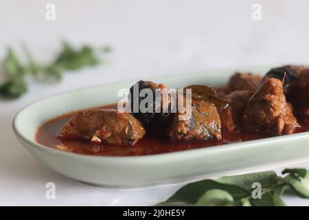 Makrelen-Currys im zentralen Kerala-Stil mit roten Chilischoten und Malabar-Tamarinde. Aufgenommen auf weißem Hintergrund. Stockfoto