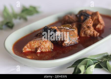 Makrelen-Currys im zentralen Kerala-Stil mit roten Chilischoten und Malabar-Tamarinde. Aufgenommen auf weißem Hintergrund. Stockfoto