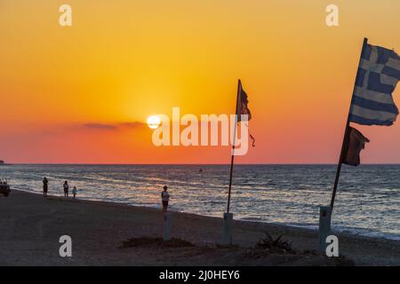 Flaggen am schönsten Sonnenuntergang Ialysos Beach Rhodos Griechenland. Stockfoto