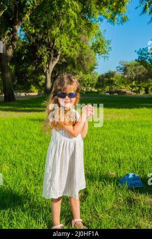 Liebenswert kleines Mädchen in Sonnenbrille Stockfoto