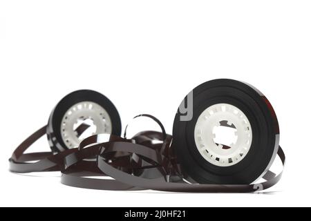 Alte Kassette mit aufgewickeltes Klebeband. Beschädigtes Datenträger für alte Tonaufnahmegeräte. Weißer Hintergrund. Stücke von einem alten Vintage-Kassettenband Stockfoto