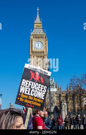 Westminster, London, Großbritannien. 19. März 2022. Am UN-Anti-Rassismus-Tag finden in vielen Städten Proteste statt, eine davon beginnt am Portland Place in London mit Themen wie dem feindlichen Umfeld für Flüchtlinge und Migranten und dem institutionellen Rassismus, der durch die jüngsten Ereignisse, einschließlich der Ukraine, hervorgehoben wird. Der marsch führt zur Downing Street und zum Parliament Square. Flüchtlinge begrüßen Plakat vor dem Parlament Stockfoto