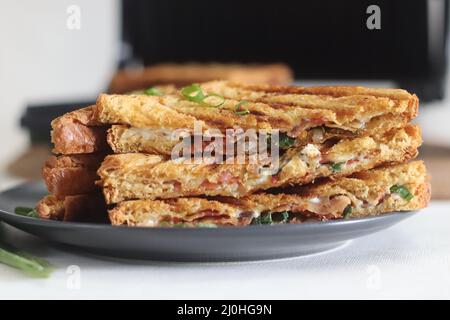 Sandwiches mit Frischkäse und Speck. Gegrillte Sandwiches mit einer Aufstrich aus einer Kombination aus Frischkäse, grünen Zwiebeln, Orangano und Chili Flocken. Schuss mit Witz Stockfoto