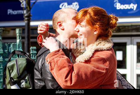 Dundee, Tayside, Schottland, Großbritannien. 19. März 2022. UK Wetter: Die Temperaturen in Teilen von Nordostschottland erreichten aufgrund der warmen März-Sonne 15 Grad. Die Einheimischen sind im Stadtzentrum von Dundee auf dem Vorweg, genießen das warme Wetter und geselligen sich. In der Nachmittagssonne kuschelt sich ein junges Paar, während es für die Kamera posiert. Kredit: Dundee Photographics/Alamy Live Nachrichten Stockfoto
