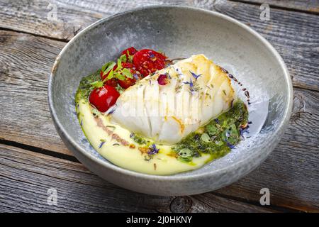 Traditionelles, gebratenes Kabeljaufischfilet im modernen Stil mit Kartoffelpüree und Koriander-Limettenreit, das als Nahaufnahme von NOR serviert wird Stockfoto