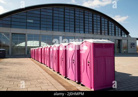 Rostock, Deutschland. 19. März 2022. Mobile Toilettenkabinen stehen vor der Hansemesse. Die Messe wird derzeit als Notunterkunft für Flüchtlinge genutzt. Die Aufnahme von manchmal hunderten Menschen aus der Ukraine in der Hansestadt Rostock pro Tag bereitet der Hansestadt Probleme. Im Vordergrund steht Covid-19, teilte Rostocks Bürgermeister C. R. Madsen (nicht-Partei) am Samstag mit. Quelle: Frank Hormann/dpa/Alamy Live News Stockfoto