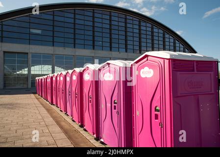 Rostock, Deutschland. 19. März 2022. Mobile Toilettenkabinen stehen vor der Hansemesse. Die Messe wird derzeit als Notunterkunft für Flüchtlinge genutzt. Die Aufnahme von manchmal hunderten Menschen aus der Ukraine in der Hansestadt Rostock pro Tag bereitet der Hansestadt Probleme. Im Vordergrund steht Covid-19, teilte Rostocks Bürgermeister C. R. Madsen (nicht-Partei) am Samstag mit. Quelle: Frank Hormann/dpa/Alamy Live News Stockfoto