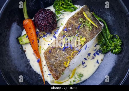 Modernes, traditionelles, gebratenes Kabeljaufischfilet mit Baby-Brokkoli Stockfoto