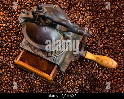 Alte antike Kaffeemühle und geröstete Kaffeebohnen Stockfoto