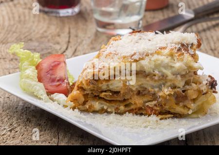 Portion Lasagne auf einem weißen Teller Stockfoto