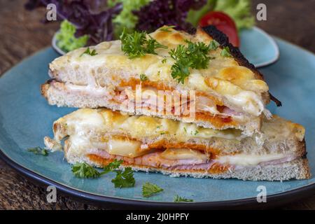 Französischer Croque monsieur auf blauem Teller Stockfoto