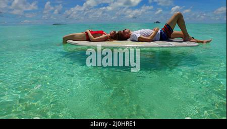 Paar liegt auf dem Surfbrett auf den Flitterwochen auf Rasdhoo Island auf den Malediven Stockfoto