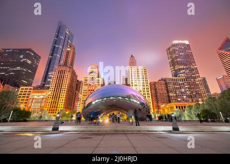 CHICAGO - ILLINOIS: 12. MAI 2018: Touristen besuchen am Abend das Cloud Gate im Millennium Park. Stockfoto