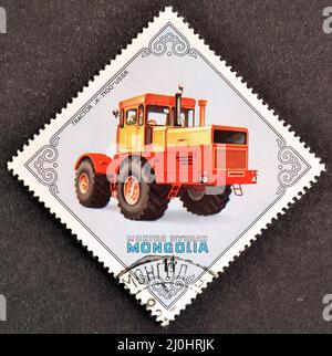 Abgesagte Briefmarke gedruckt von der Mongolei, die Traktor zeigt, K-7100, UdSSR, um 1982. Stockfoto